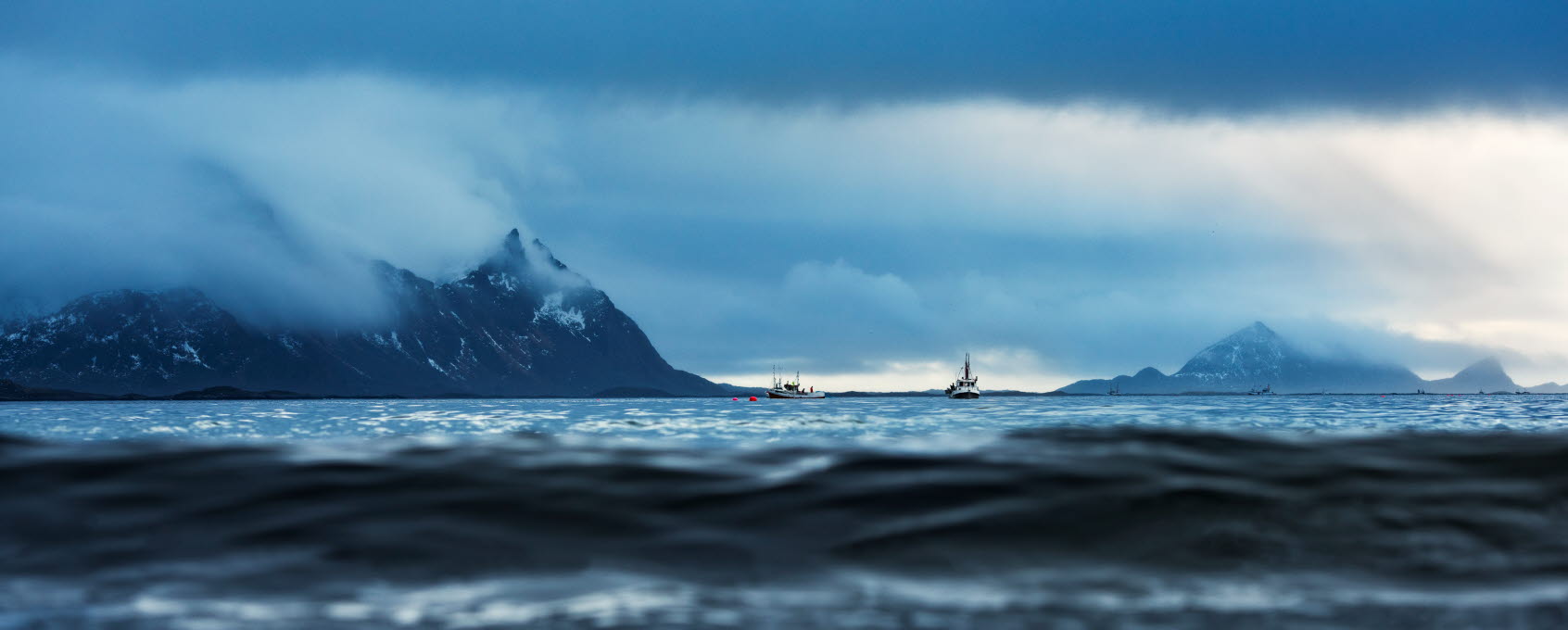Sea in dark and stormy weather, mountains in the background